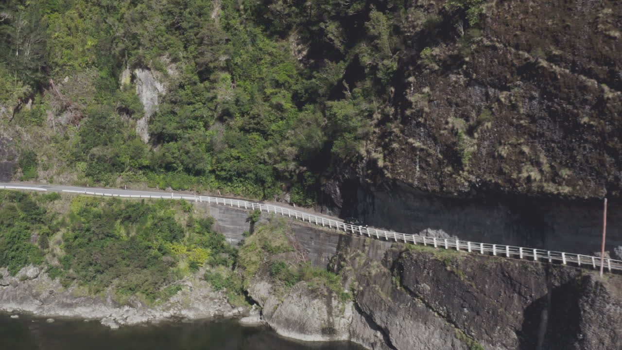 뉴질랜드 남섬의 볼러 골짜기 아래쪽의 은 도로를 따라 달리는 차.