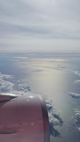 view from a plane window of the sky with the wing shot in vertical