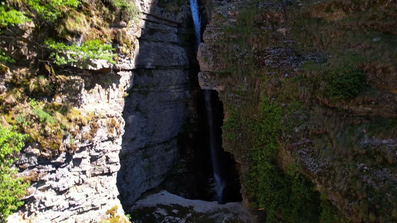 hermosa cascada en la ladera de una montaña rocosa que cae dentro del cañón en colores turquesa, albania