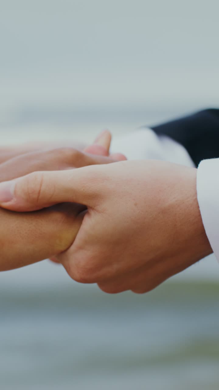 una pareja de manos en la playa.