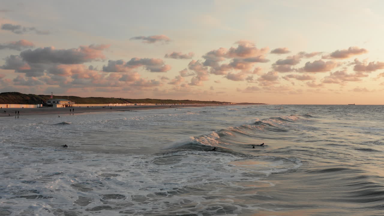 Surfisti di fronte alla città turistica di Domburg nei Paesi Bassi al tramonto.