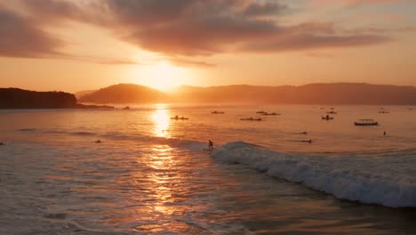 sunrise at the surf spots of gerupuk in lombok, with a view on the bay with the fishing boats and surfers