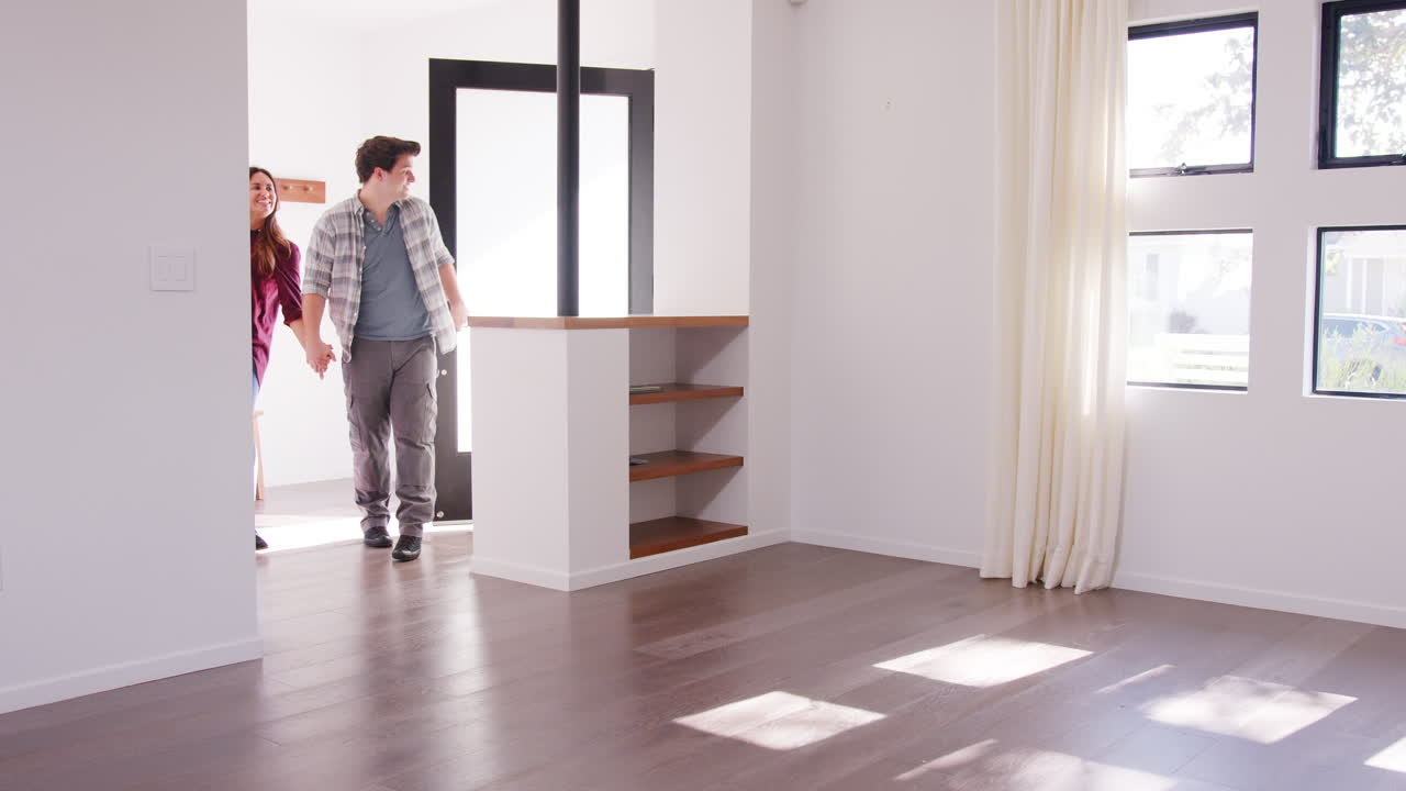 una familia emocionada con un bebé explorando un nuevo hogar el día de la mudanza