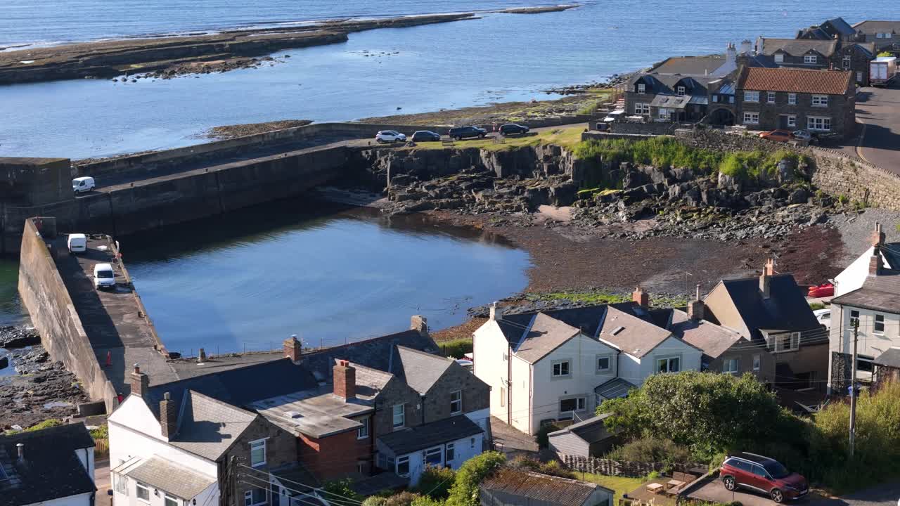 drone footage of Craster harbor village in Northumberland on a summers day morning