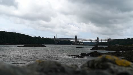 Blick-über-Den-Unscharfen-Felsvordergrund-Zur-Menai-Straits-Britannia-Bridge-Nach-Anglesey