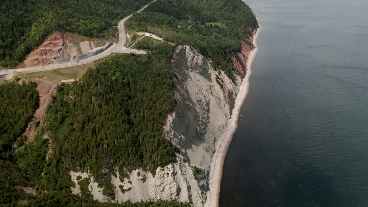 автомобили едут и путешествуют по горной дороге в солнечный день на полуострове гаспе у пышного зеленого леса в квебеке, канада