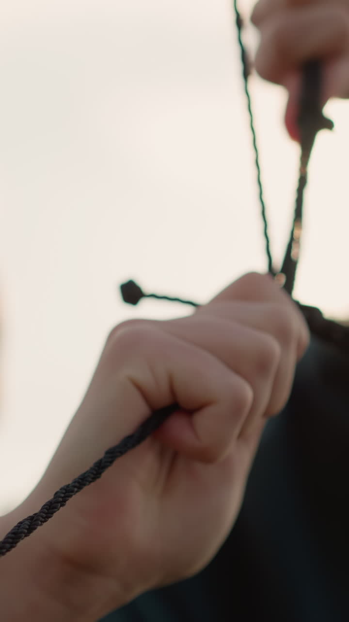 초록색 스웨터를 입은 사람이 들고 있는 배구망의 클로즈업, 얼굴이 약간 흐릿해져 있고, 황금색 빛이 그녀를 둘러싸고 반사되어 따뜻하고 집중된 분위기를 만니다.