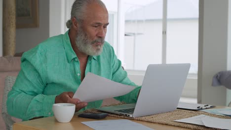 mature man using laptop at home