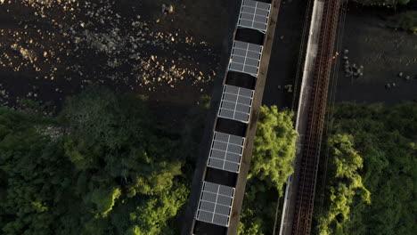 Toma-Aérea-De-Arriba-Hacia-Abajo-De-Paneles-Solares-En-Una-Vía-De-Monorraíl-Abandonada-En-Japón