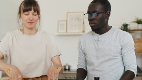 pareja multiétnica cocinando ensalada de verduras con mozzarella