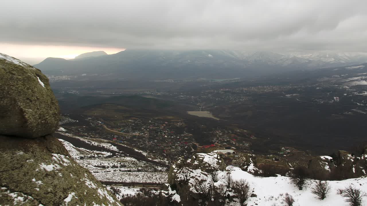 Vinterberglandskap med snö och byutsikt