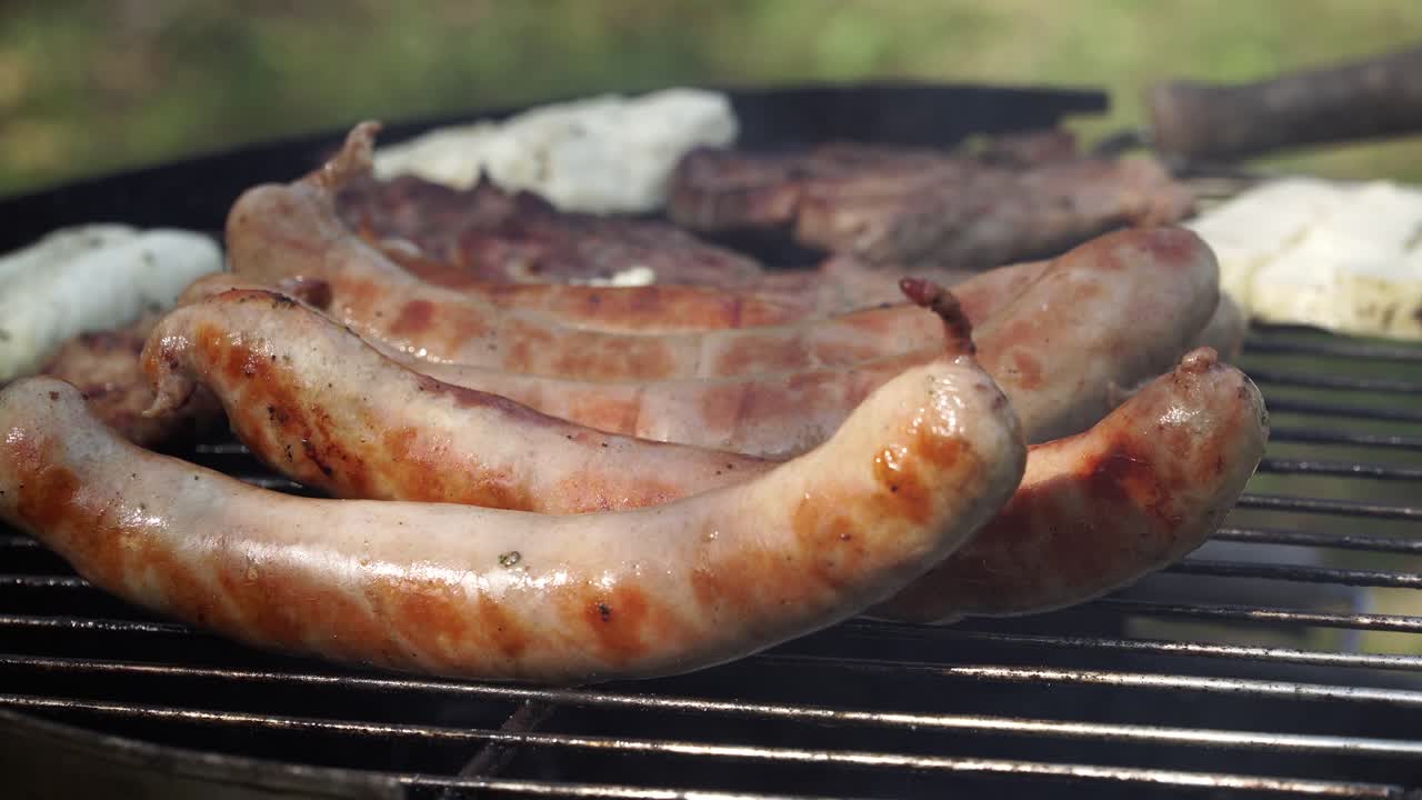 salchichas alemanas en una parrilla caliente para una deliciosa barbacoa en la naturaleza