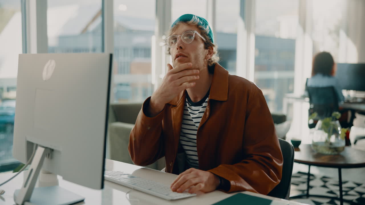 hombre trabajando en una computadora en una oficina moderna