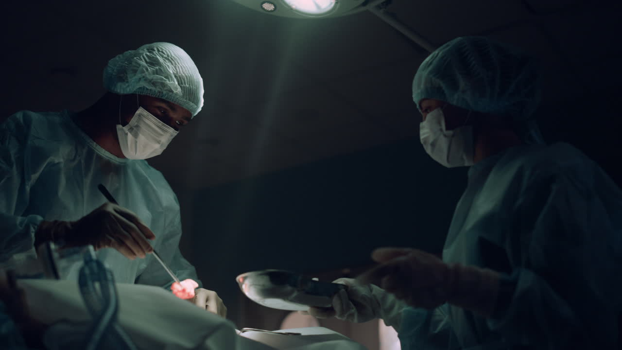 어두운 응급실에서 수술하는 외과의사, 피가 묻은  ⁇ 폰을 복용하는 의료 종사자