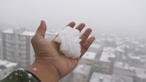 hand holding snow in city