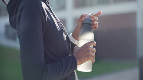 fitness, water bottle and hands of person in city