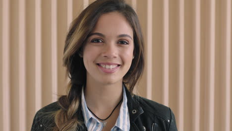 bonita mujer hispana retrato de una hermosa mujer joven sonriendo feliz ante la cámara con una elegante chaqueta de cuero en un fondo de madera