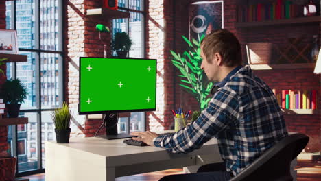 trabajador remoto que realiza investigación de proyectos, escribiendo en un dispositivo de pantalla verde