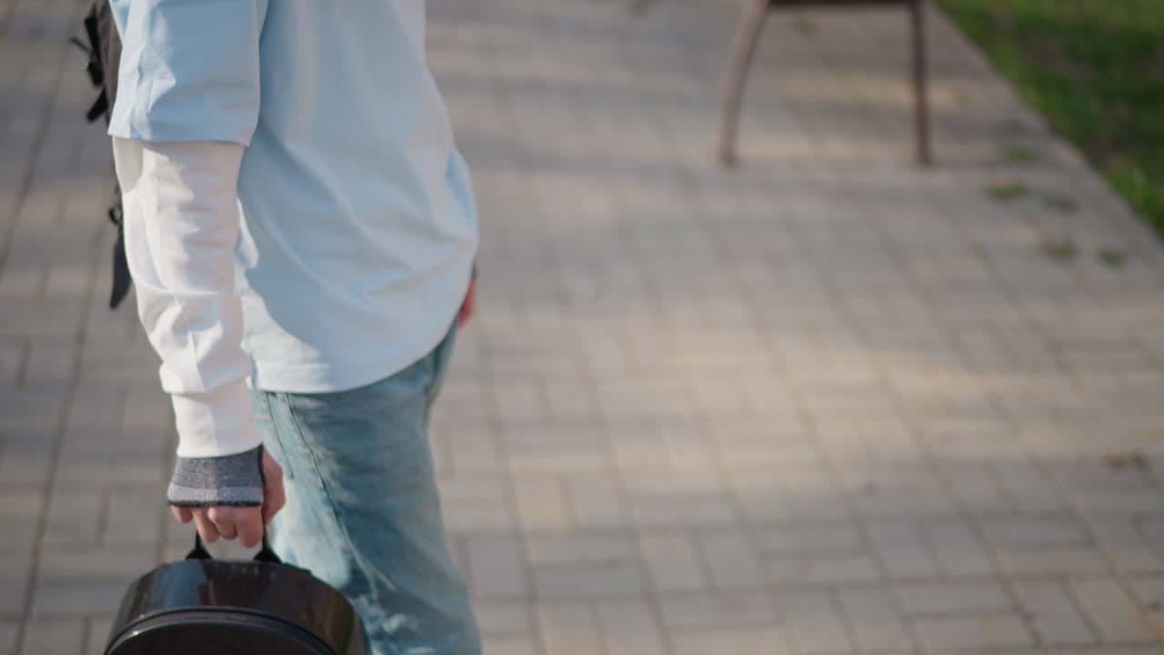 도시 캐주얼 복장을 한 십 대, 편안한 복장으로 도시를 거닐며 여유를 즐기는 십 대, 캐주얼한 도시 의류를 입고 포장된 도시 대로를 따라 배낭을 느긋하게 흔드는 젊은 십 대