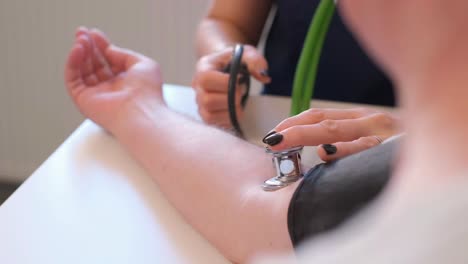 asian caring caregiver look after senior woman patient at nursing home. beautiful therapist doctor examine and measure heart rate through stethoscope on elderly grandmother patient on sofa in house.