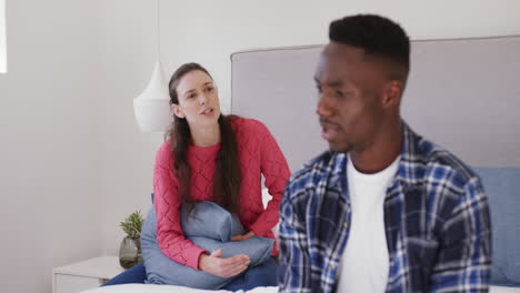 una pareja enojada y diversa discutiendo y gritando en el dormitorio en casa, en cámara lenta.