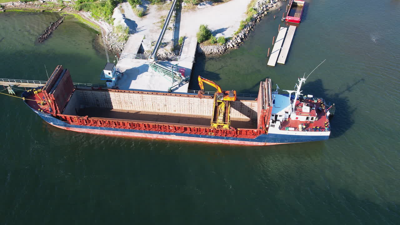 Cargo ship being loaded with materials at a harbor in Stenungsund