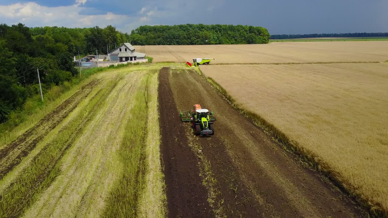 Green Tractor Working In A Field. VINNITSA, UKRAINE - JULY 2017: Aerial shot of the green tractor working in a field or farmland