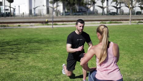 beautiful young woman training with coach in parkland.