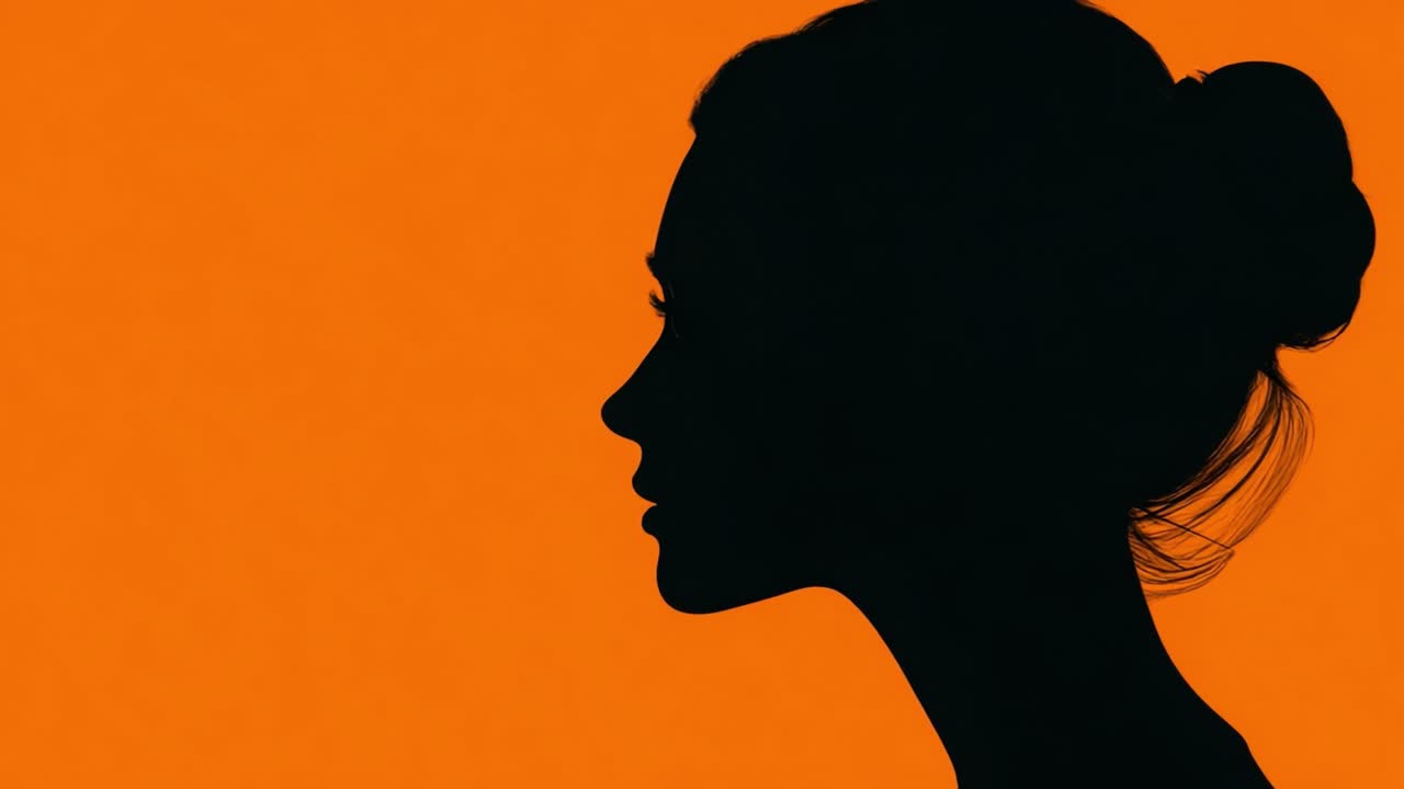 Silhouette del profilo di una donna su sfondo arancione, che cattura un momento di contemplazione e bellezza in stile minimalista