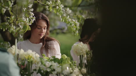 Mujeres-Hermosas-En-Una-Fiesta-En-El-Jardín-En-Primavera-Sentadas-A-La-Mesa-Con-Flores-En-Flor-En-El-Huerto