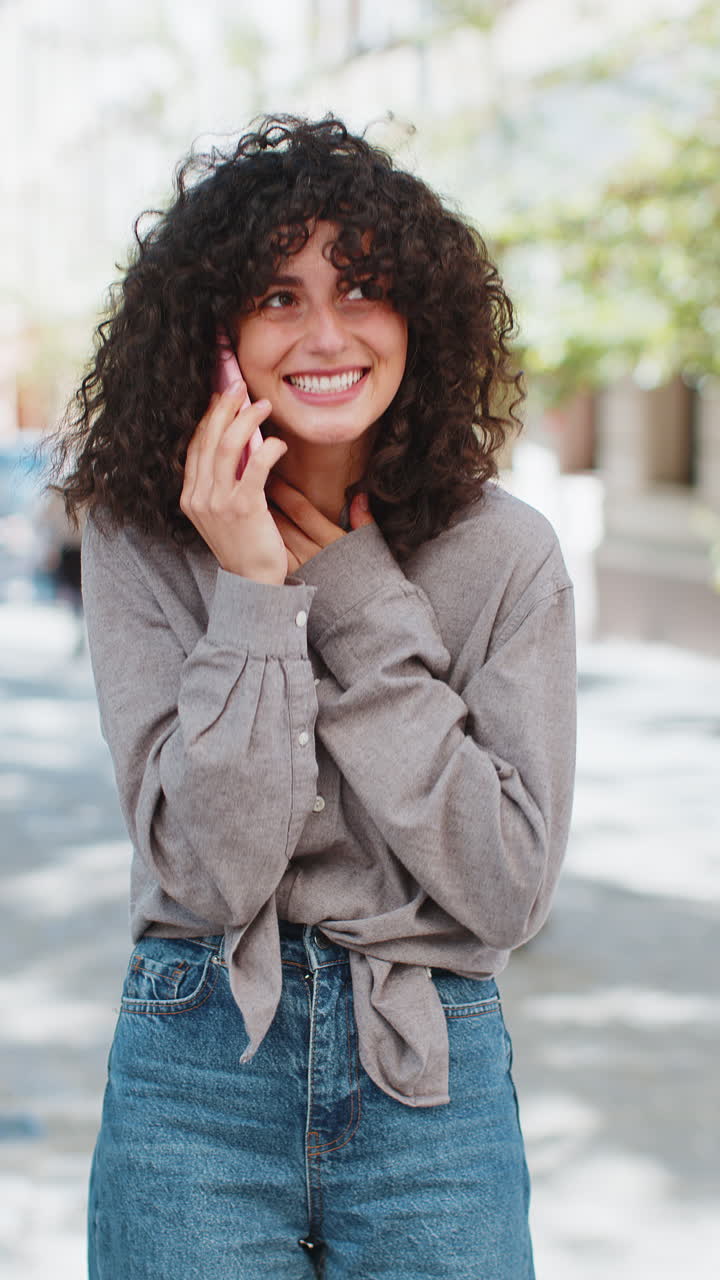 mujer feliz teniendo conversación remota hablando en teléfono inteligente buenas noticias chismes en la calle de la ciudad