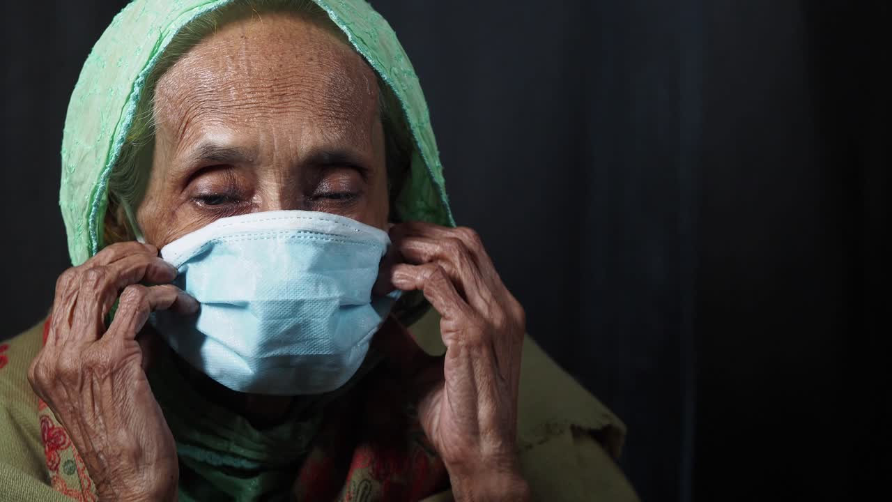 Elderly Woman Adjusting and Wearing a Protective Face Mask