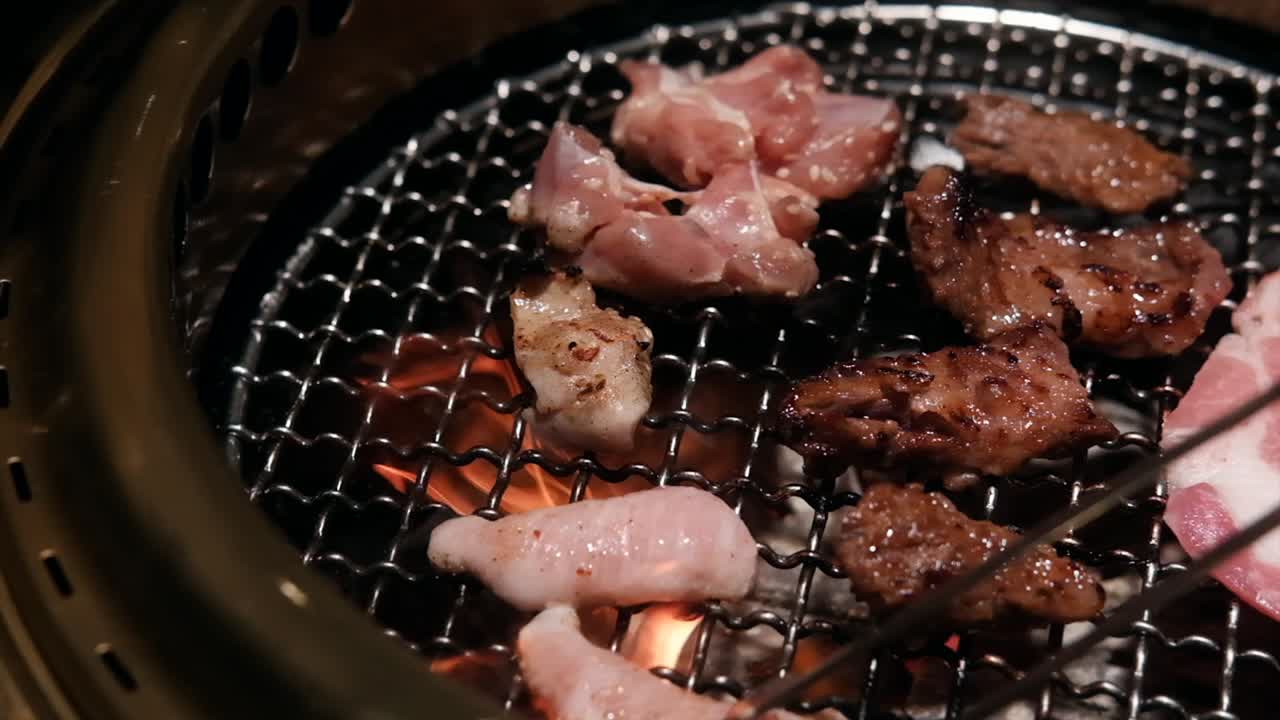 Close-up of juicy Korean BBQ meat sizzling on a hot grill, captured in dramatic slow motion. Flames and smoke, creating a mouthwatering, atmospheric cooking scene. Ideal for lifestyle, travel project