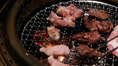 close-up of juicy korean bbq meat sizzling on a hot grill, captured in dramatic slow motion. flames and smoke, creating a mouthwatering, atmospheric cooking scene. ideal for lifestyle, travel project