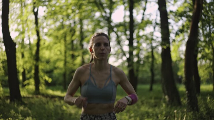 Женщина бежит в лесу.