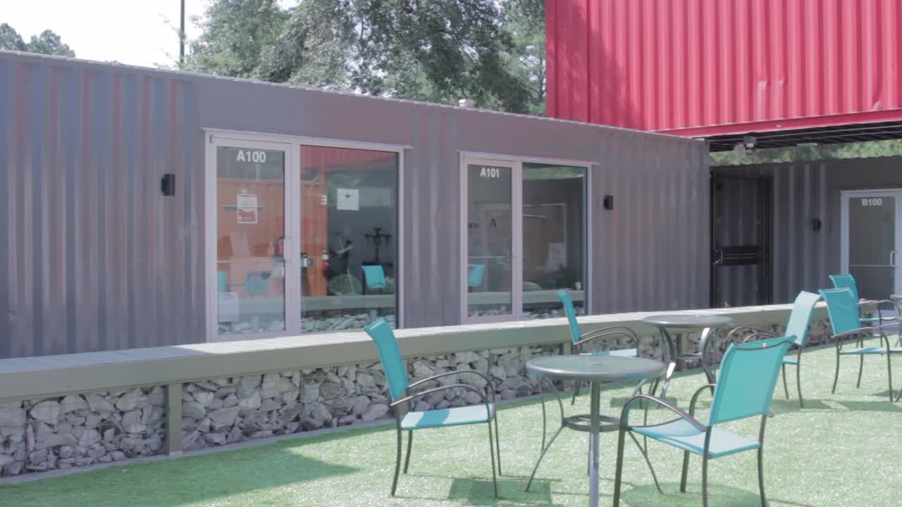 Industrial shipping container style business with patio furniture in front