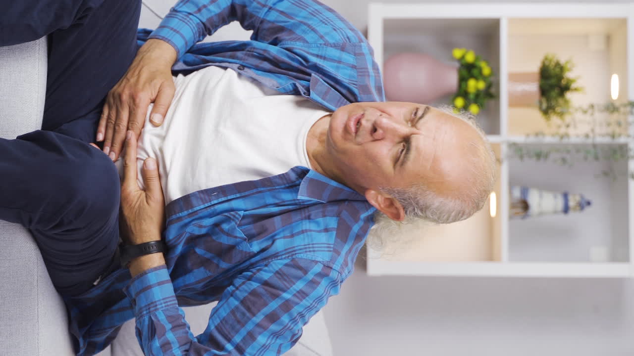 video vertical de un anciano con dolor de estómago.