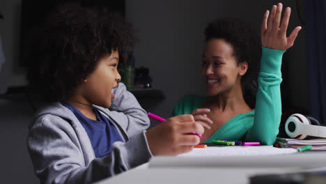 Mixed-race-mother-and-daughter-drawing-in-a-notebook