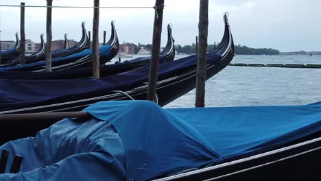 venetian gondolas at venice canal dock, rocking in water