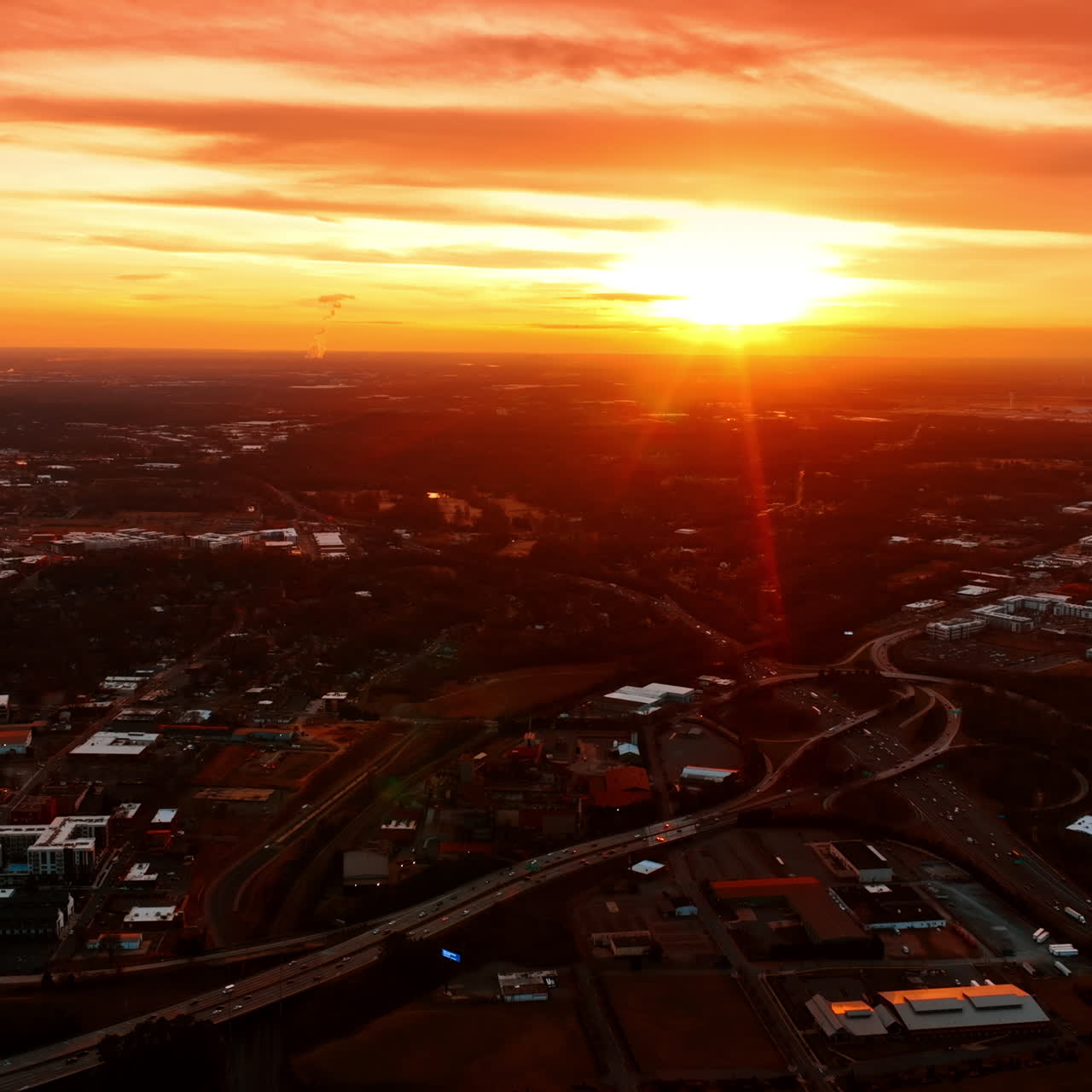 Bright sun setting above the cityscape. Aerial perspective on Charlotte, North Carolina, USA from top perspective.