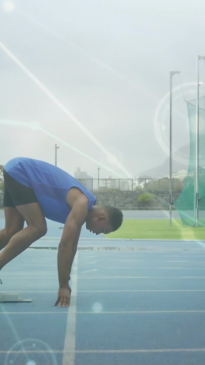 Vertical video: Runner starting from blocks racing down blue track as lit nodes showing sports data