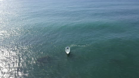 aerial forward tilt down on isolated motorboat in open sea