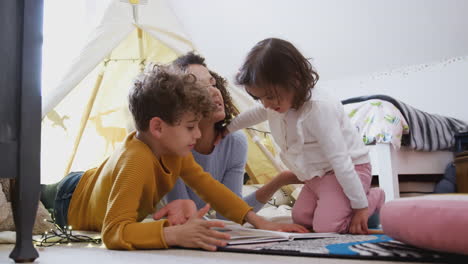 single mother reading with son and daughter in den in bedroom at home