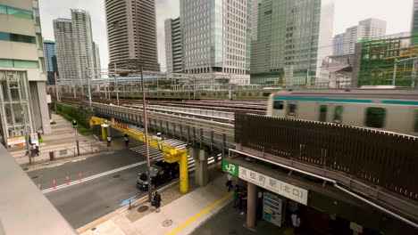 toyko subway trains pass over street on elevated track