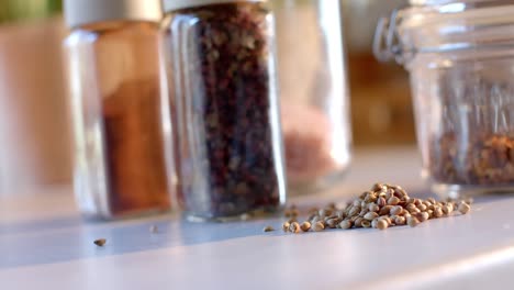 storage jars of seasonings on countertop in sunny kitchen, slow motion