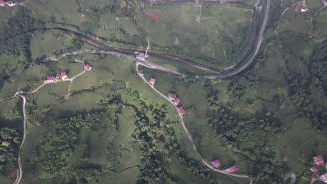 Drohnenansicht-Der-Zufahrtsstraßen-Zu-Den-Auf-Dem-Hügel-Gebauten-Häusern,-Der-Siedlung-Im-Grünen