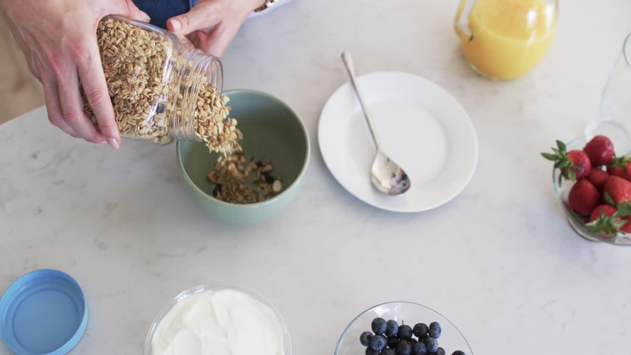 una mujer caucásica de mediana edad prepara el desayuno en casa.