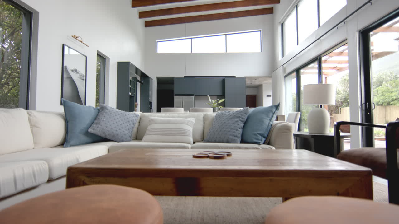 Interior of bright open plan living room, dining room and kitchen, copy space, slow motion