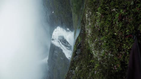 reveal of husedalen waterfall from inside tent, vertical handheld view