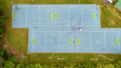 drone footage captures multiple sports courts with people playing, showcasing vibrant colors and dynamic movement from above